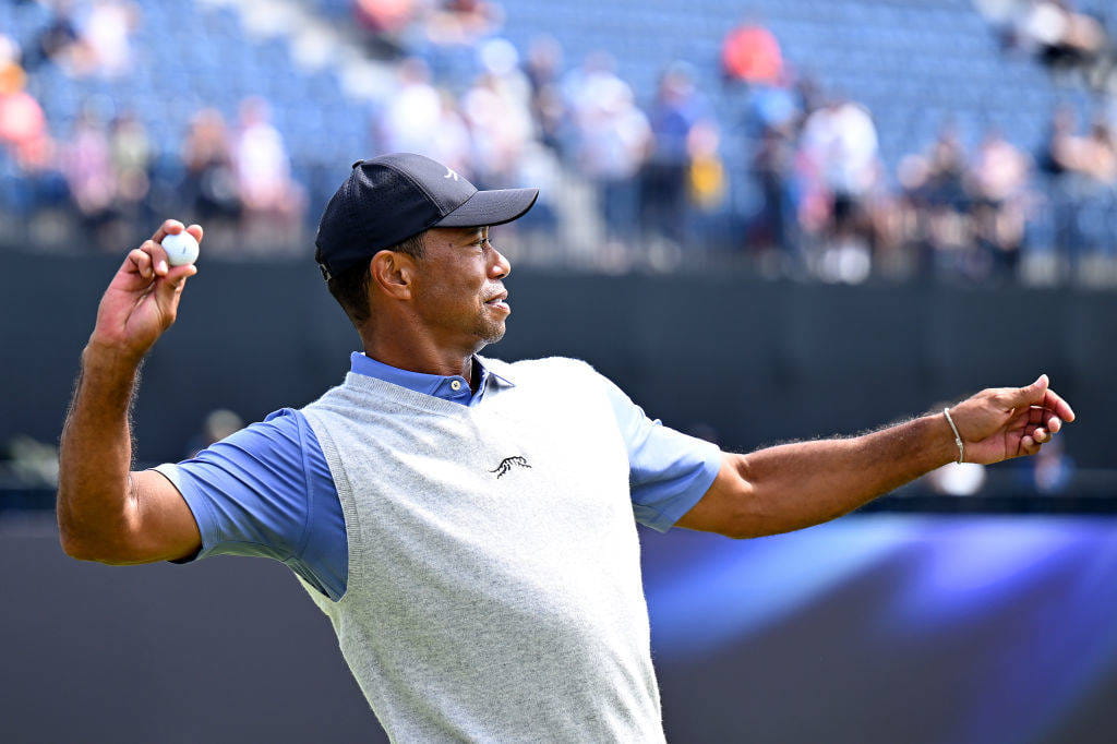Tiger Woods of the United States throws his ball to a fan during a practice round prior to The 152nd Open